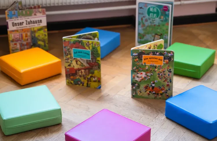 Leseecke der Luba Uelzen, bunte Bücher und bunte Sitzkissen.