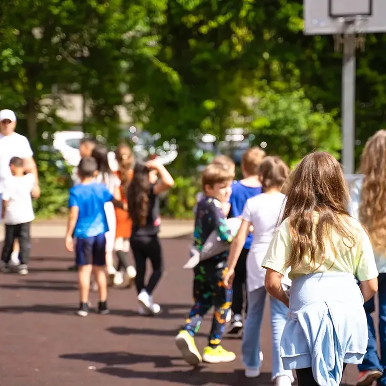 zeigt kinder auf dem Schulhof der Lukas-Backmeister-Schule.