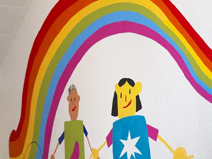 Zeigt eine Tafel mit dem Wort Einschulung darüber bunte Fähnchen.