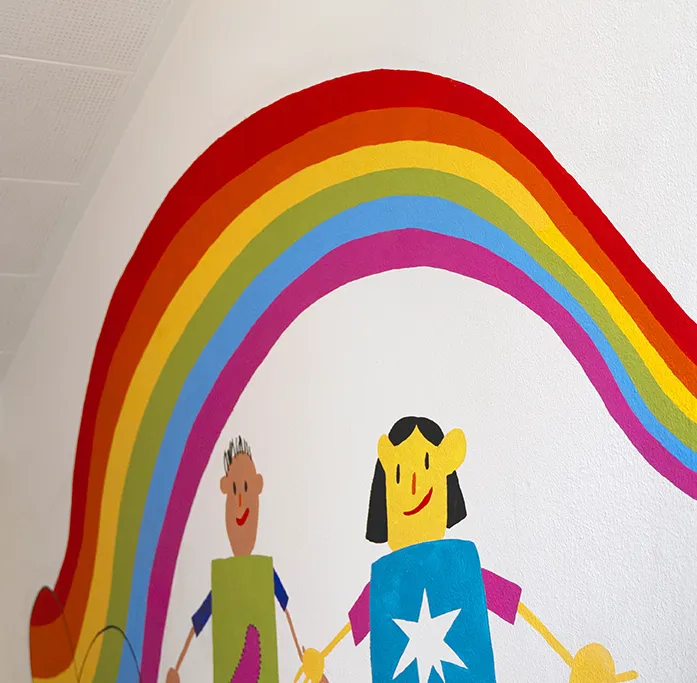 zeigt eine Wandmalerei in der Luba, zwei Kinder unter einem Regenbogen